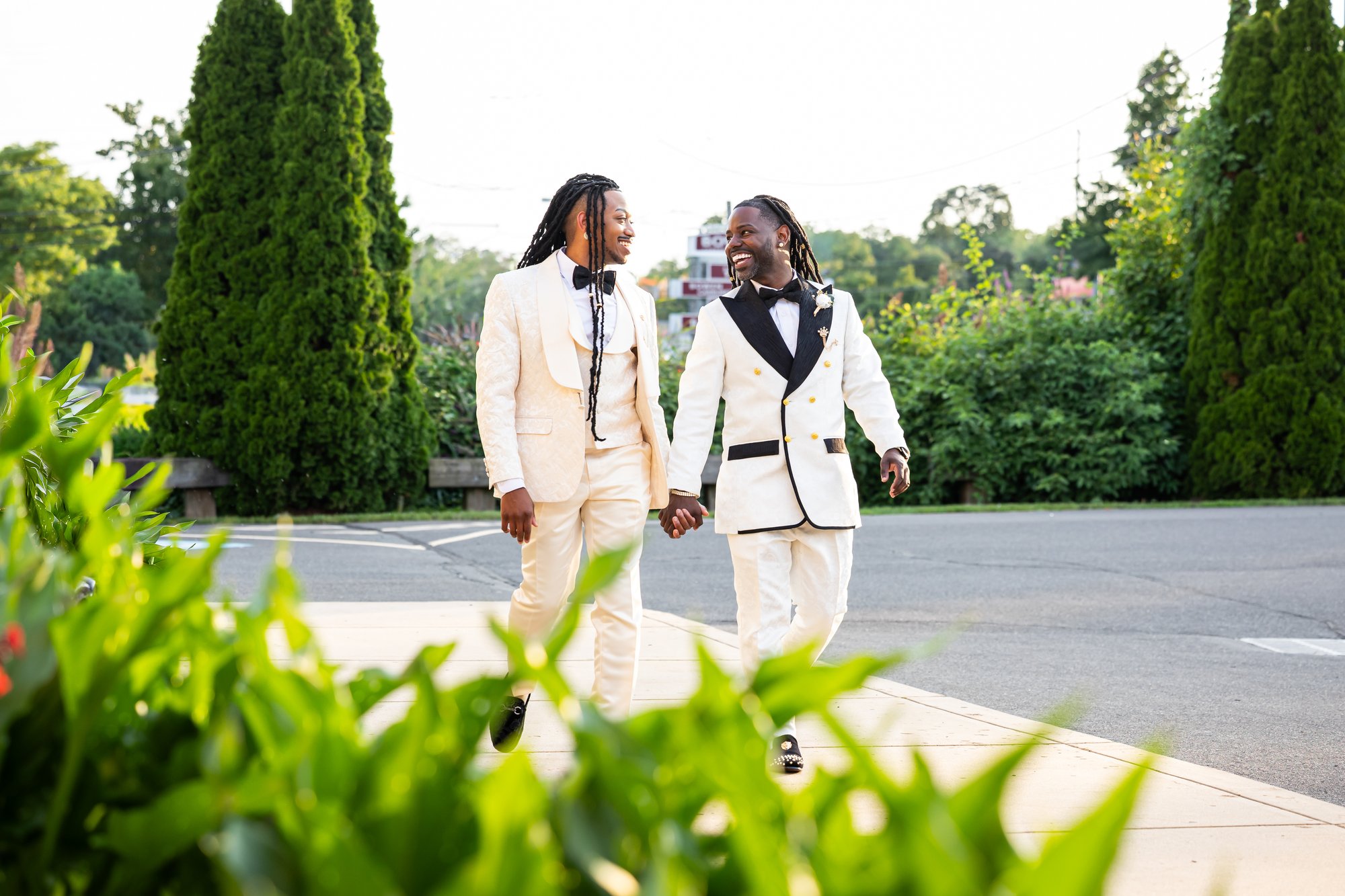 Two grooms walking hand in hand at their Falls Manor wedding in Bristol, Bucks County