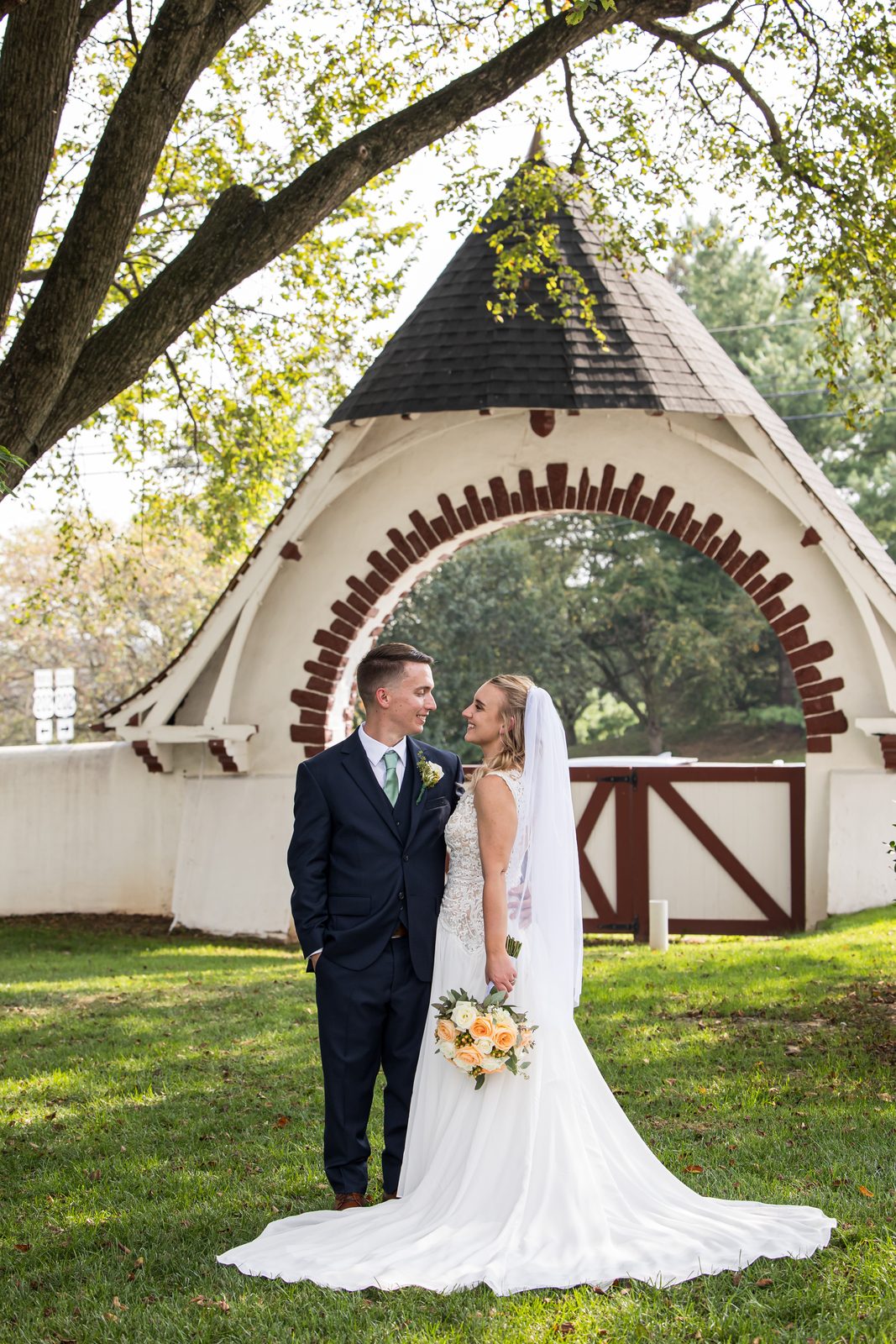 Bride and groom beneath the stone arch at Normandy Farm in Blue Bell, Montgomery County, Pennsylvania