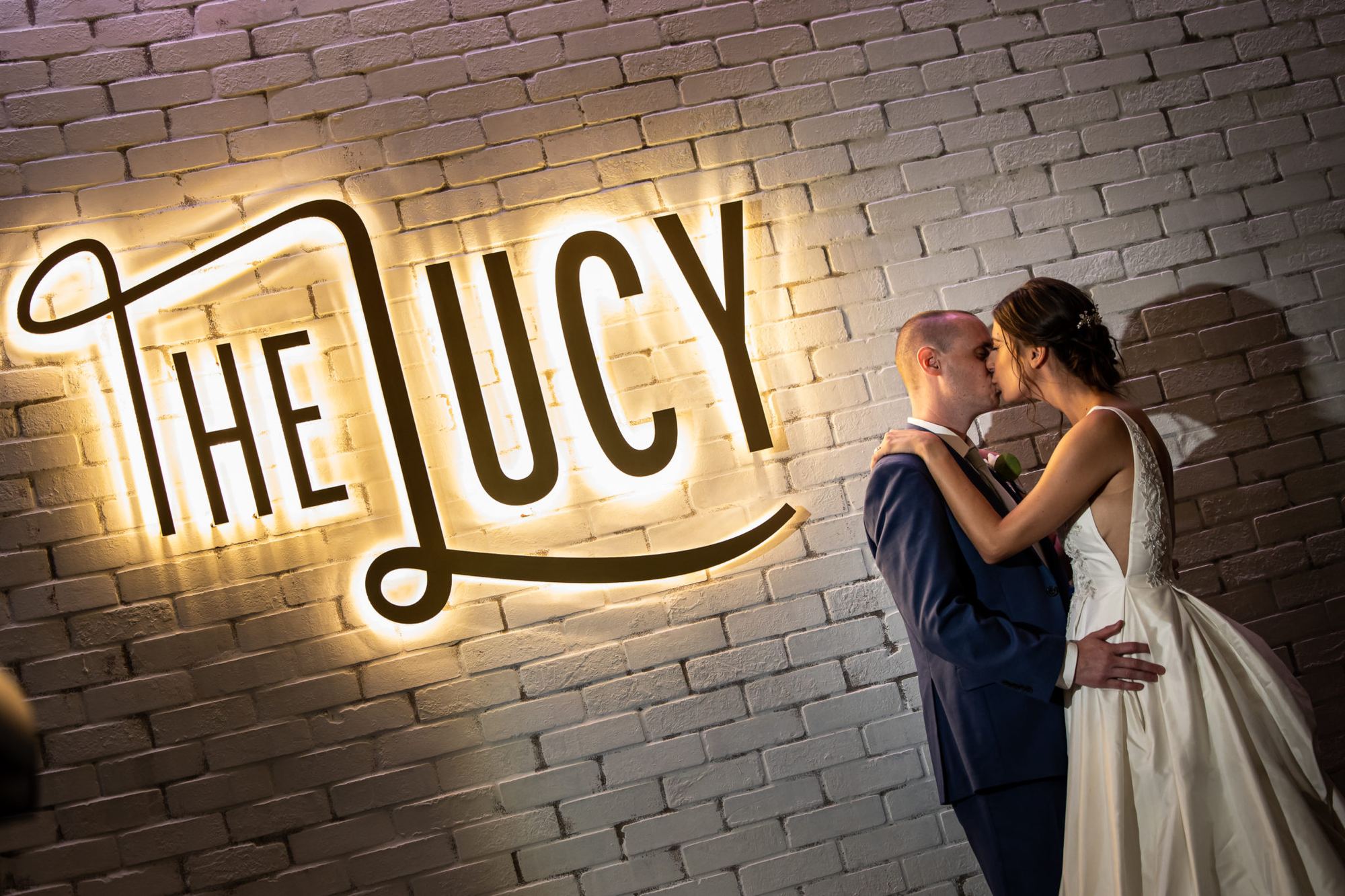 Bride and groom beside the neon sign at The Lucy in Philadelphia
