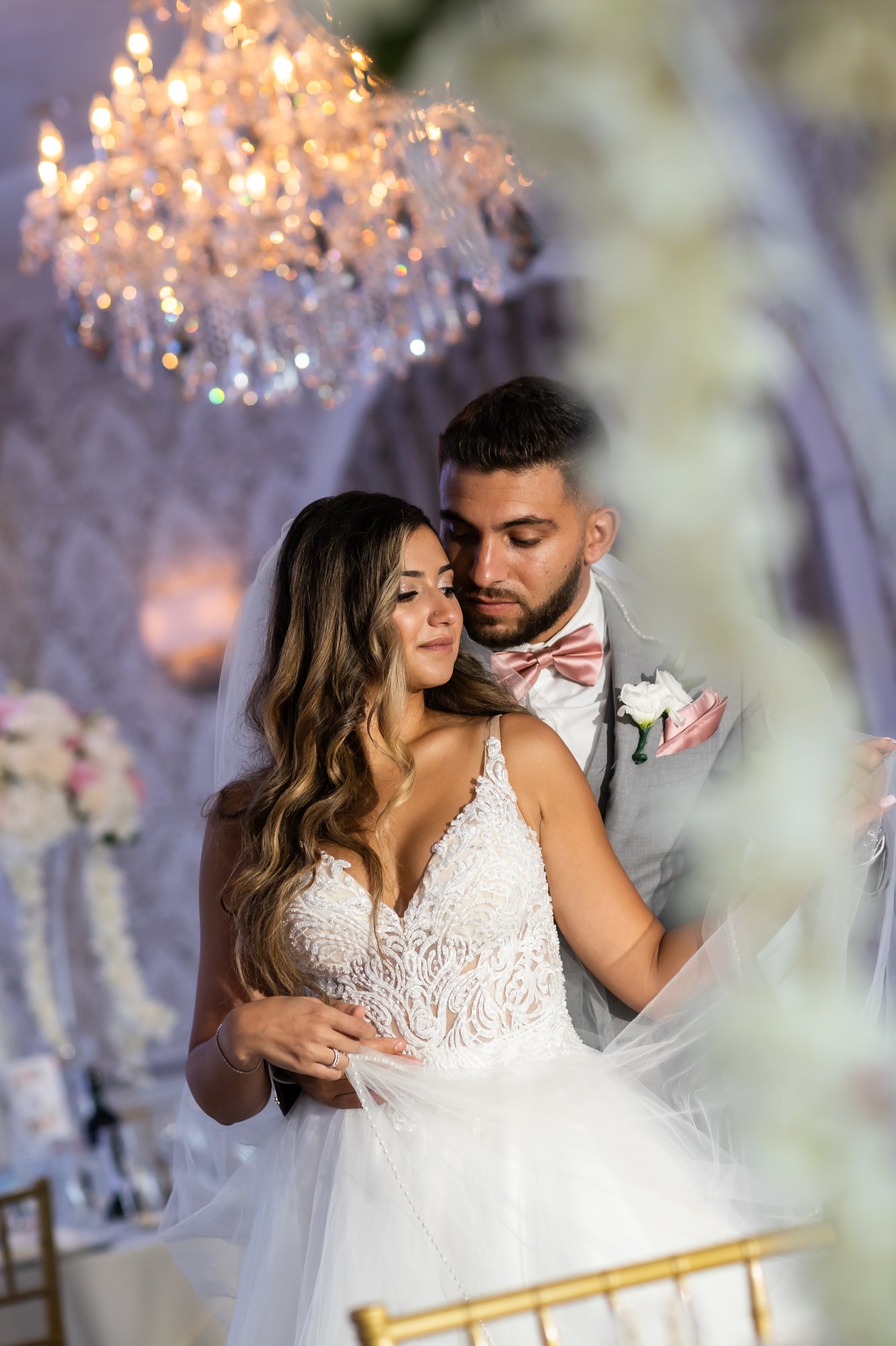 Bride and groom beneath the chandeliers at The Merion in Cinnaminson, New Jersey